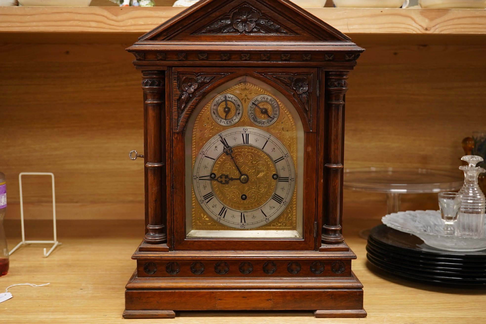 A German Gothic style oak mantel clock, early 20th century, with pendulum and keys, 49cm high